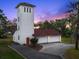 A three-car garage and tower are made of stucco with a clay tile roof to match the primary home at 37918 N County Road 44A, Eustis, FL 32736