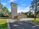 View of the two-car garage and adjacent tower, complemented by a paved driveway at 37918 N County Road 44A, Eustis, FL 32736