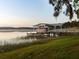 Lakeside view of a dock and boat house surrounded by grass and trees at 37918 N County Road 44A, Eustis, FL 32736