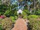 Picturesque landscaped grounds feature a charming brick walkway and decorative archway entry with lush plants and beautiful trees at 37918 N County Road 44A, Eustis, FL 32736