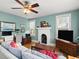 Cozy living room featuring a decorative fireplace, ceiling fan, and bright natural light from the windows at 37918 N County Road 44A, Eustis, FL 32736