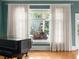 Bright living room with a grand piano, large window with sheer curtains, and hardwood floors at 37918 N County Road 44A, Eustis, FL 32736