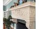 Ornate stone mantel with intricate carvings above a fireplace, complemented by a potted plant at 37918 N County Road 44A, Eustis, FL 32736
