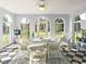Bright sunroom with black and white flooring, white wicker furniture, and an outside view through multiple windows at 37918 N County Road 44A, Eustis, FL 32736