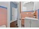 Bathroom with pink tiles, a white sink and cabinet and view into the next room at 401 N Oleander Ave, Daytona Beach, FL 32118