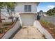 White single-car garage with brick trim, stairs, and a small yard at 401 N Oleander Ave, Daytona Beach, FL 32118