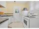 Charming kitchen with white appliances, door to the outside and ample counter space with black and yellow accent tiles at 401 N Oleander Ave, Daytona Beach, FL 32118