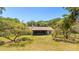 Large backyard featuring trees with mature landscaping and a rear building at 486 S Us Highway 1, Oak Hill, FL 32759