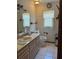 Bathroom featuring a sink, toilet, mirror, and window at 486 S Us Highway 1, Oak Hill, FL 32759