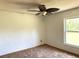 Bedroom featuring carpet floors, a ceiling fan, and a window offering natural light at 486 S Us Highway 1, Oak Hill, FL 32759