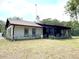Charming single-story home with a screened porch, chimney, and landscaped flowerbeds under a cloudy sky at 486 S Us Highway 1, Oak Hill, FL 32759