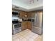 Kitchen featuring stainless steel appliances, tile flooring, and wooden cabinets at 486 S Us Highway 1, Oak Hill, FL 32759
