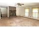Spacious living room featuring a brick fireplace, ceiling fan, and carpeted floors at 486 S Us Highway 1, Oak Hill, FL 32759