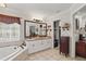 Bright bathroom featuring double sinks, soaking tub, vanity cabinet, and an entrance to the walk-in closet at 5865 Ross Creek Rd, Lakeland, FL 33810