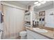 Well lit bathroom featuring a shower with a decorative curtain, a toilet, and a vanity at 5865 Ross Creek Rd, Lakeland, FL 33810