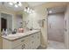 Bathroom with double sinks, granite countertops, white cabinets and tiled shower at 5865 Ross Creek Rd, Lakeland, FL 33810