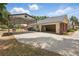 Side angle of the home featuring a covered carport, garage, landscaped exterior, and manicured lawn at 5865 Ross Creek Rd, Lakeland, FL 33810