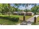 Traditional style home boasts manicured lawn, mature trees, and gated driveway at 5865 Ross Creek Rd, Lakeland, FL 33810