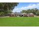 Charming single-story brick home with a well-manicured lawn and mature trees at 5865 Ross Creek Rd, Lakeland, FL 33810