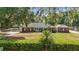 Charming brick home with a well-manicured lawn, mature trees, and a detached garage at 5865 Ross Creek Rd, Lakeland, FL 33810