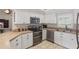 Modern kitchen featuring stainless steel appliances and white cabinetry at 5865 Ross Creek Rd, Lakeland, FL 33810