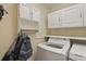 Laundry room with white cabinets and modern washer and dryer units at 5865 Ross Creek Rd, Lakeland, FL 33810