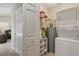 Compact laundry area with a stackable washer/dryer, water heater, and storage shelves at 5865 Ross Creek Rd, Lakeland, FL 33810