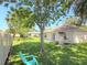 Spacious backyard featuring lush green grass, privacy fence, mature trees, and an inviting exterior space at 613 Clairmont Ln, South Daytona, FL 32119