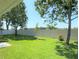 Private backyard featuring lush green grass, privacy fence, mature trees, and a tranquil outdoor space at 613 Clairmont Ln, South Daytona, FL 32119