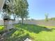 Serene backyard featuring lush green grass, a charming swing, privacy fence, and mature trees at 613 Clairmont Ln, South Daytona, FL 32119