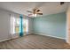 Relaxing bedroom with wood-look floors, complemented by soft natural light from the window at 613 Clairmont Ln, South Daytona, FL 32119