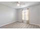 Bright bedroom with light gray walls, ceiling fan and updated flooring, and window with curtain at 613 Clairmont Ln, South Daytona, FL 32119
