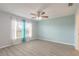 Bright bedroom featuring a ceiling fan and natural light from a window with decorative curtains at 613 Clairmont Ln, South Daytona, FL 32119