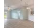 Bright, open-concept living room featuring modern floors, a ceiling fan, and seamless flow to the kitchen at 613 Clairmont Ln, South Daytona, FL 32119