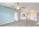 Airy living room with a ceiling fan, sleek floors, and a seamless transition to the kitchen and hallway at 613 Clairmont Ln, South Daytona, FL 32119