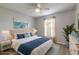 Staged bedroom featuring laminate wood flooring and a beach-themed painting at 613 Clairmont Ln, South Daytona, FL 32119