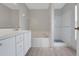 Bathroom showcasing vanity with sink, soaking tub, and a walk-in shower with white tile at 881 Westline Ave, Deltona, FL 32725