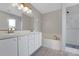 Bathroom featuring double sink vanity, soaking tub, and walk-in shower with tile accents at 881 Westline Ave, Deltona, FL 32725