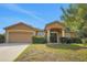 Charming home with a two-car garage, well-maintained lawn, and inviting front entrance with decorative columns at 881 Westline Ave, Deltona, FL 32725