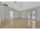 Living room with tile floor, ceiling fan and french doors overlooking backyard at 881 Westline Ave, Deltona, FL 32725