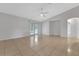 Spacious living room with tile flooring, ceiling fan, and French doors leading to the outside at 881 Westline Ave, Deltona, FL 32725