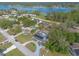 Aerial view of a home in a lakeside community featuring mature trees, solar panels, circular drive and lush landscape at 991 Dawson Dr, Deltona, FL 32725