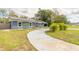 Landscaped front yard leading to a cozy home with a driveway, solar panels, and a welcoming pathway at 991 Dawson Dr, Deltona, FL 32725