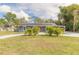 Charming home exterior with lush green lawn, solar panels, and a vibrant red front door at 991 Dawson Dr, Deltona, FL 32725