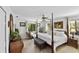 Spacious main bedroom with a four-poster bed, natural light from the windows, and elegant decor at 1 Crooked Bridge Way, Ormond Beach, FL 32174