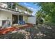 Fenced backyard with patio, lawn chairs, and shade trees at 1502 Deer Springs Rd, Port Orange, FL 32129