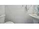 Powder room with a white toilet, single pedestal sink and modern fixtures at 1502 Deer Springs Rd, Port Orange, FL 32129