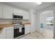 Bright kitchen features white cabinets, stainless steel appliances, and modern flooring at 1502 Deer Springs Rd, Port Orange, FL 32129