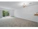 Spacious living room with carpet flooring and sliding glass doors to a patio at 1502 Deer Springs Rd, Port Orange, FL 32129