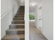 Carpeted stairs lead to a bright living space with a large window view, complemented by neutral paint at 1502 Deer Springs Rd, Port Orange, FL 32129